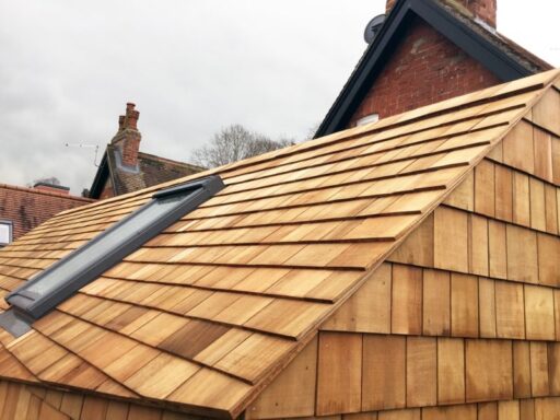 New cedar shingles installed around a skylight on a sloped roof