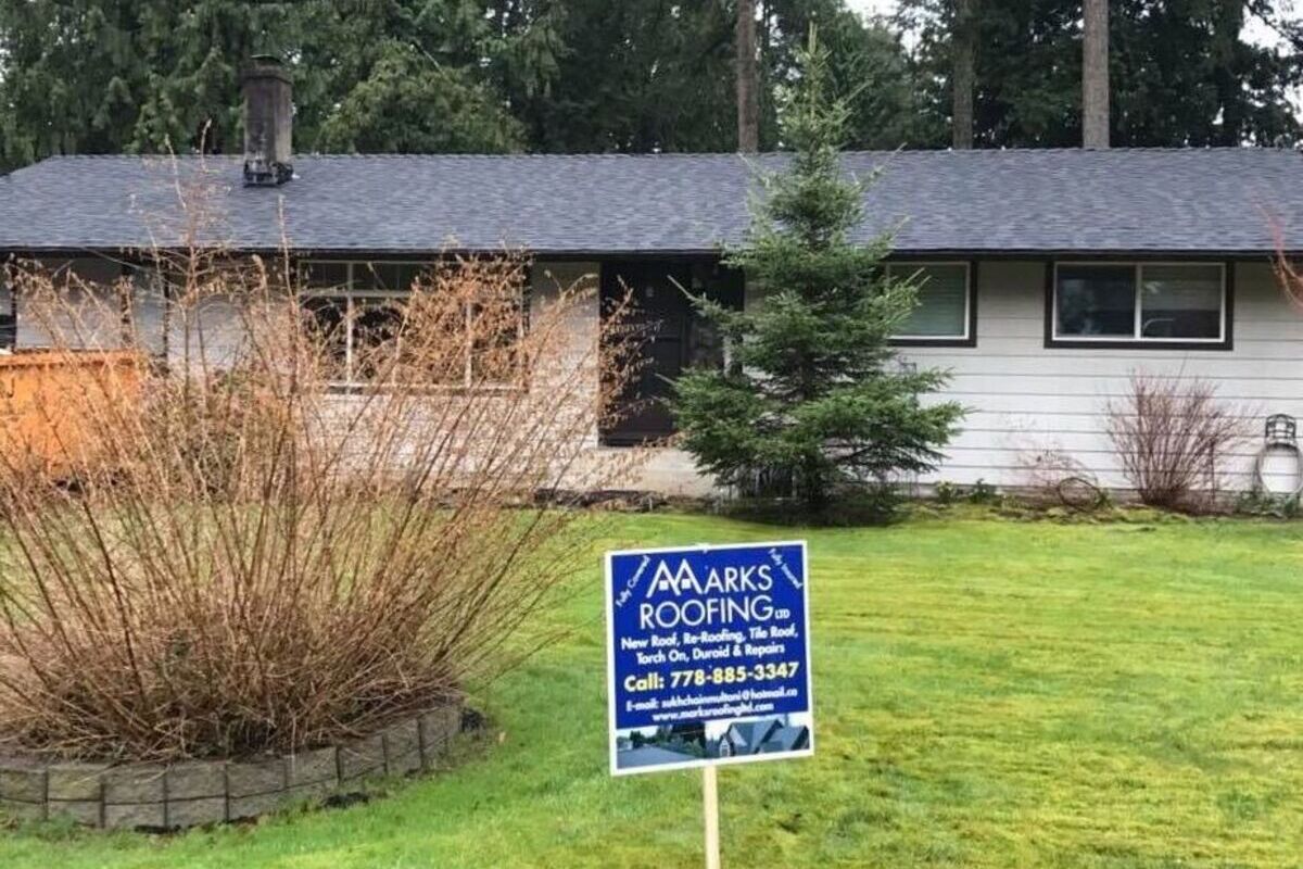 New asphalt shingle roof on a home in Vancouver with roofing company sign on the lawn