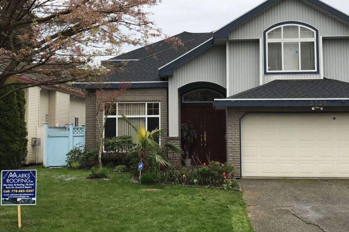 Fresh asphalt roofing on a family home in Vancouver with black shingles and company sign