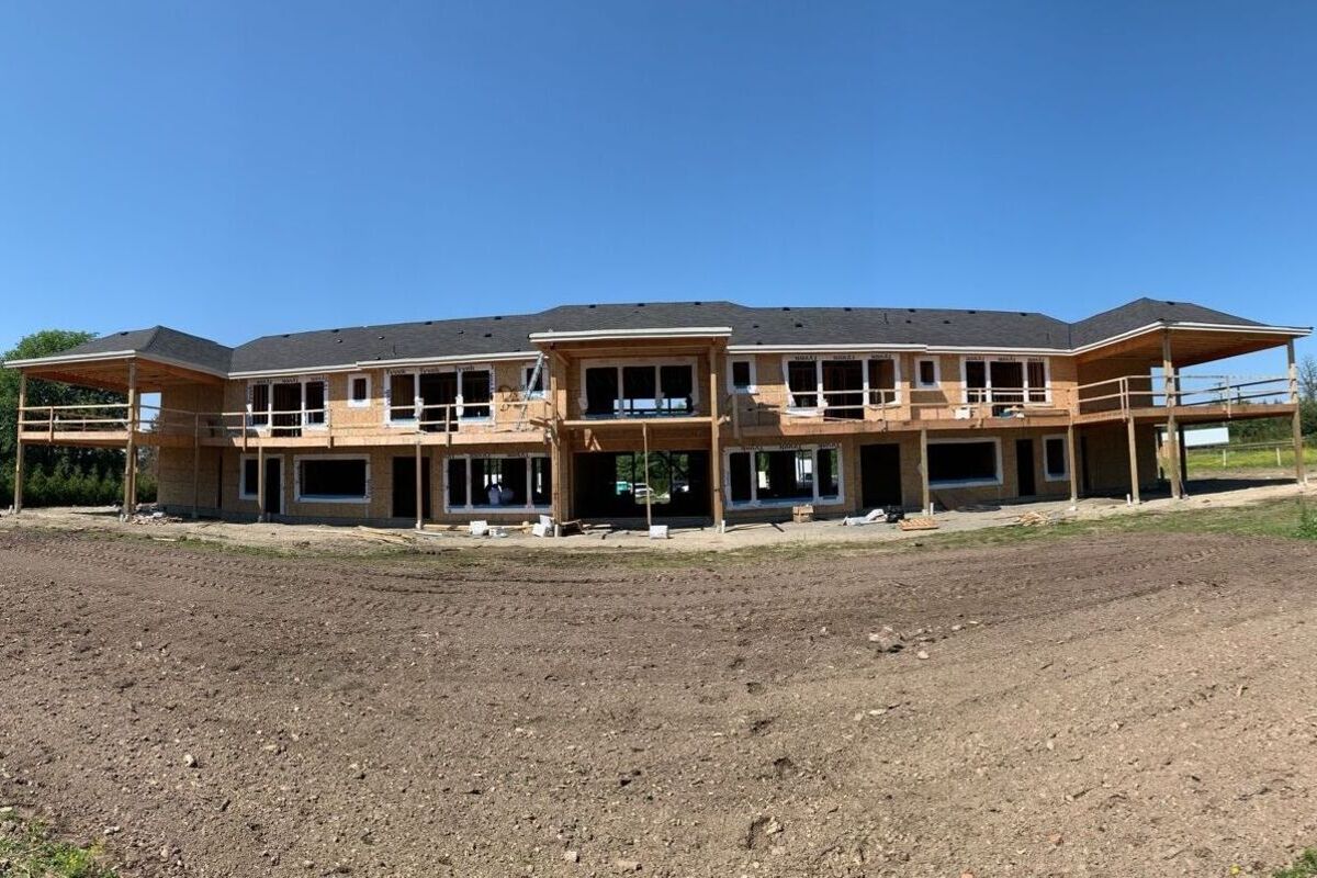 Multifamily roof installation in Vancouver featuring black asphalt shingles, roof vents and active construction work