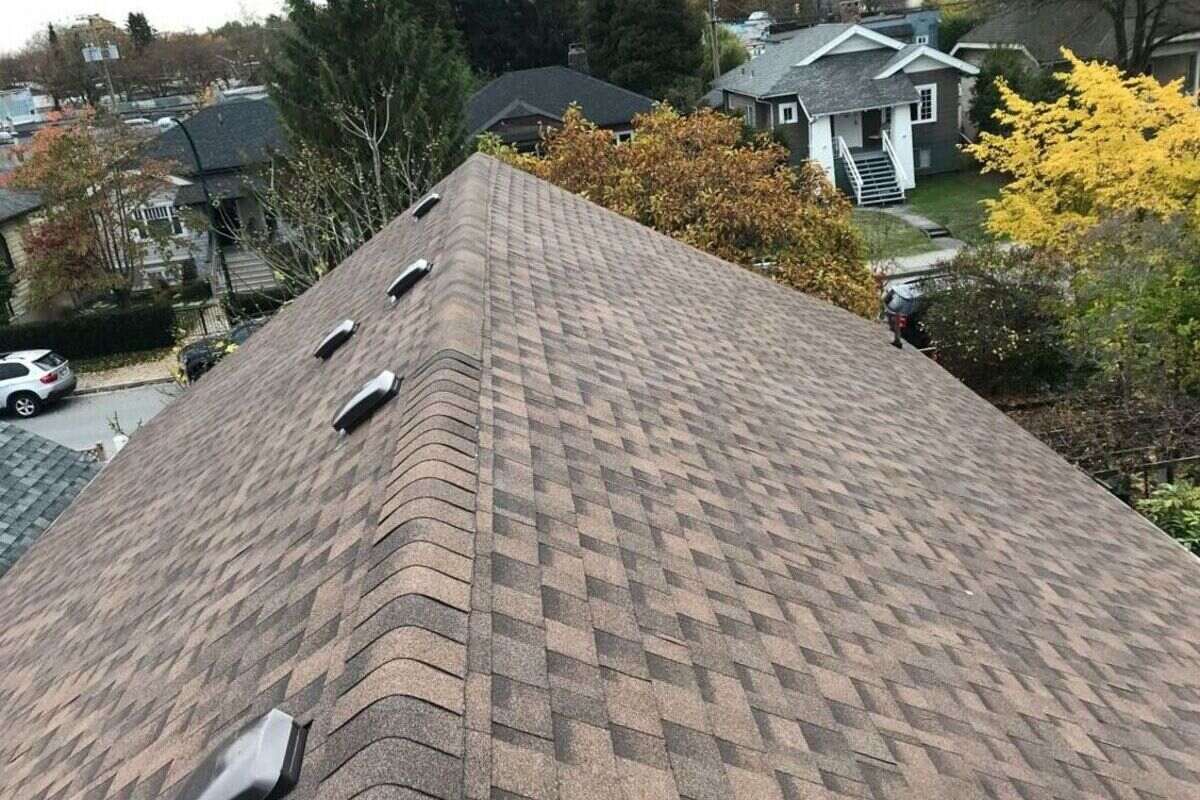 Architectural asphalt shingles installed on a residential roof in Vancouver with visible roof vents and trees nearby