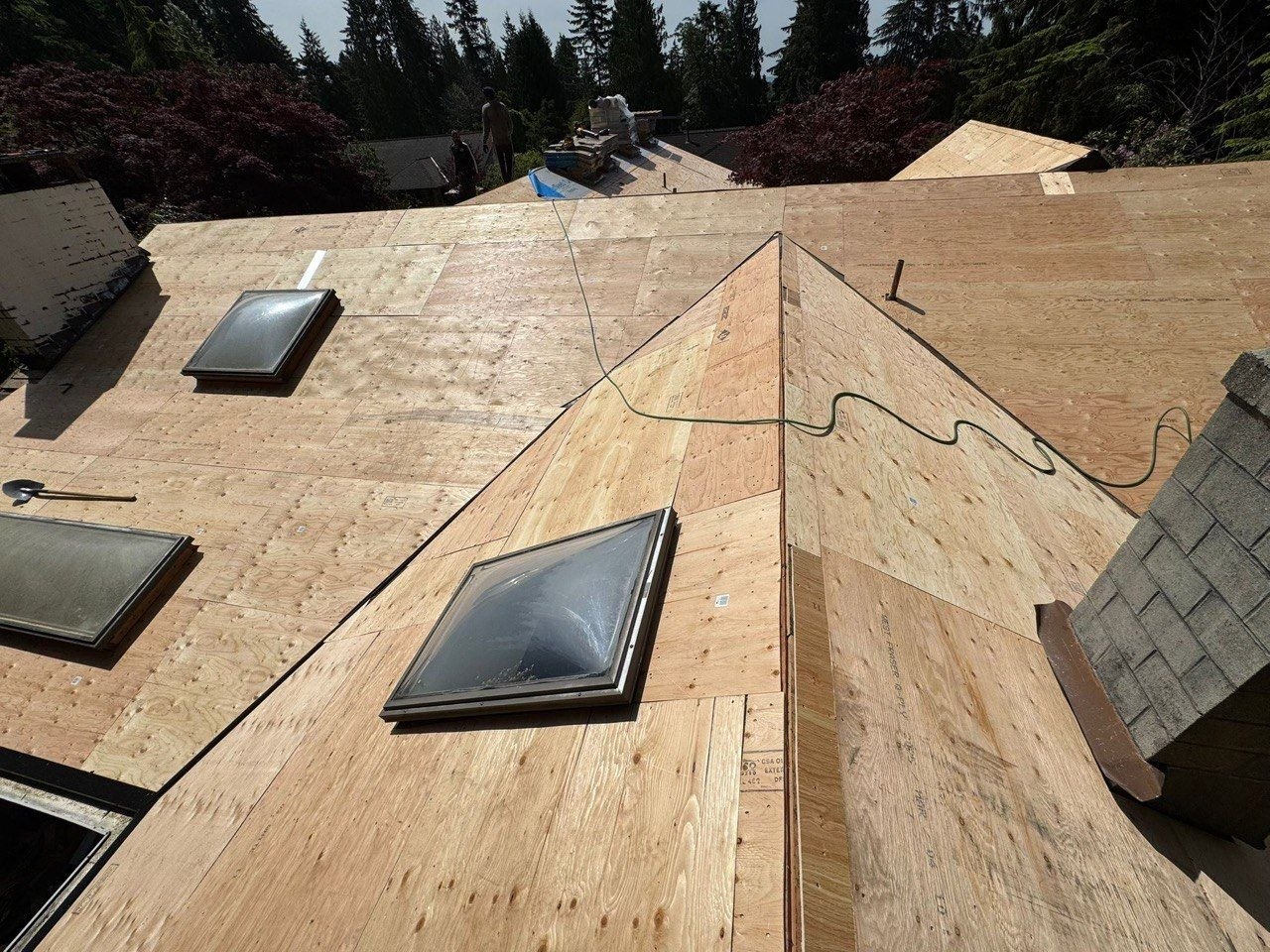 Marks Roofing is installing new plywood roof decking around skylights during a residential roof replacement project.