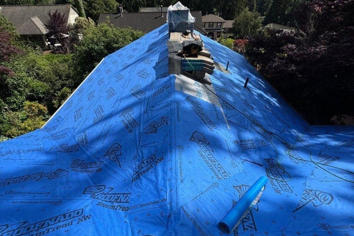 Marks Roofing is installing synthetic roof underlayment on a residential roof during a full roof replacement project.