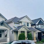 Multi-family residential homes with connected roof sections and dark asphalt shingles, showing strata roofing access and planning considerations.
