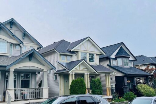 Multi-family residential homes with connected roof sections and dark asphalt shingles, showing strata roofing access and planning considerations.